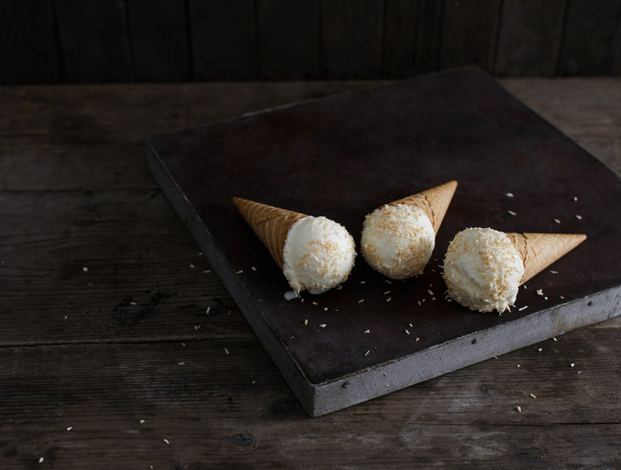 Coconut ice cream in cones displayed on a slate plate